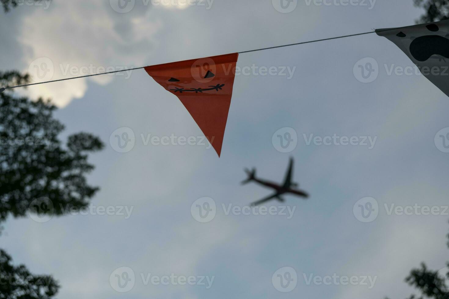 fiesta banderas para Víspera de Todos los Santos decoración hecho de papel colgando con avión antecedentes. foto