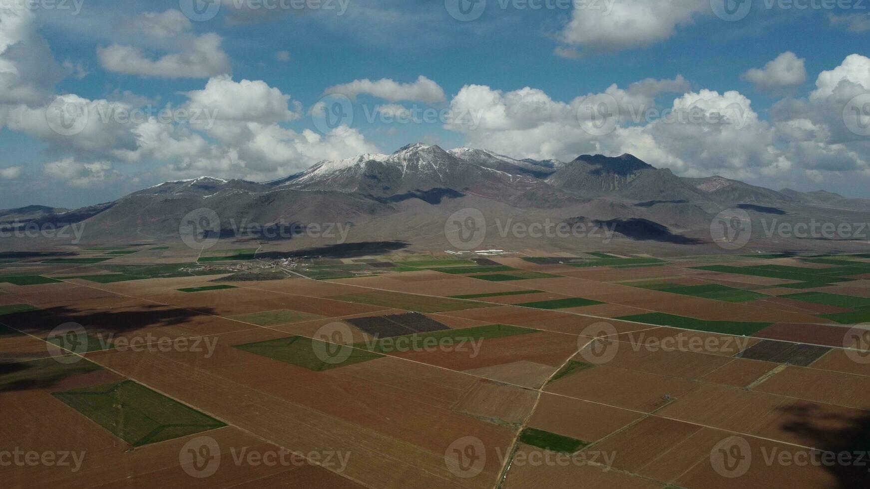 Drone view over farmland against snowy mountain photo