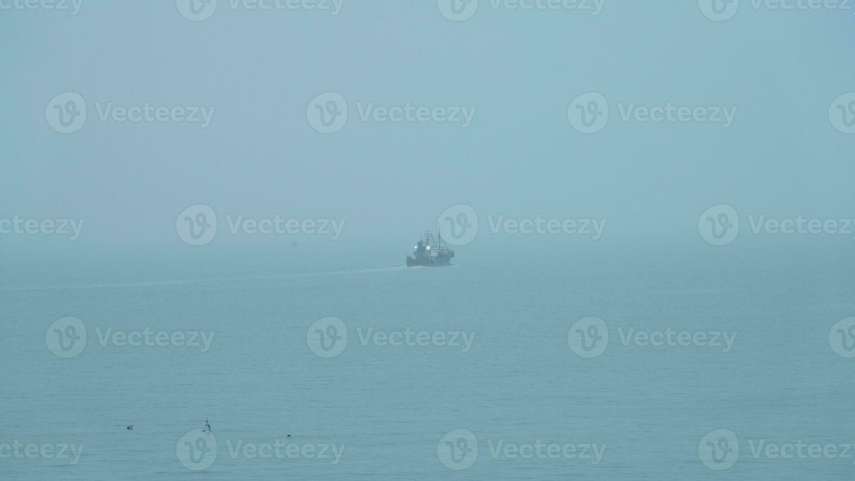 The peaceful sea view with the fishing boat sailing on it in the cloudy day photo