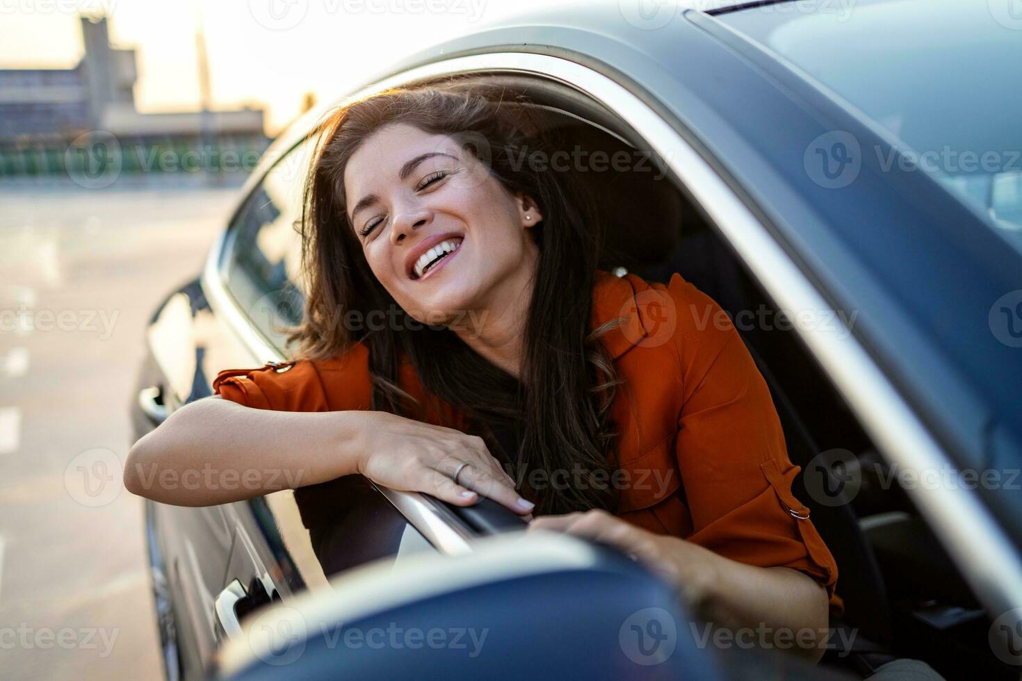 recortado Disparo de un atractivo joven mujer propensión fuera de un coche ventana en un la carretera viaje foto