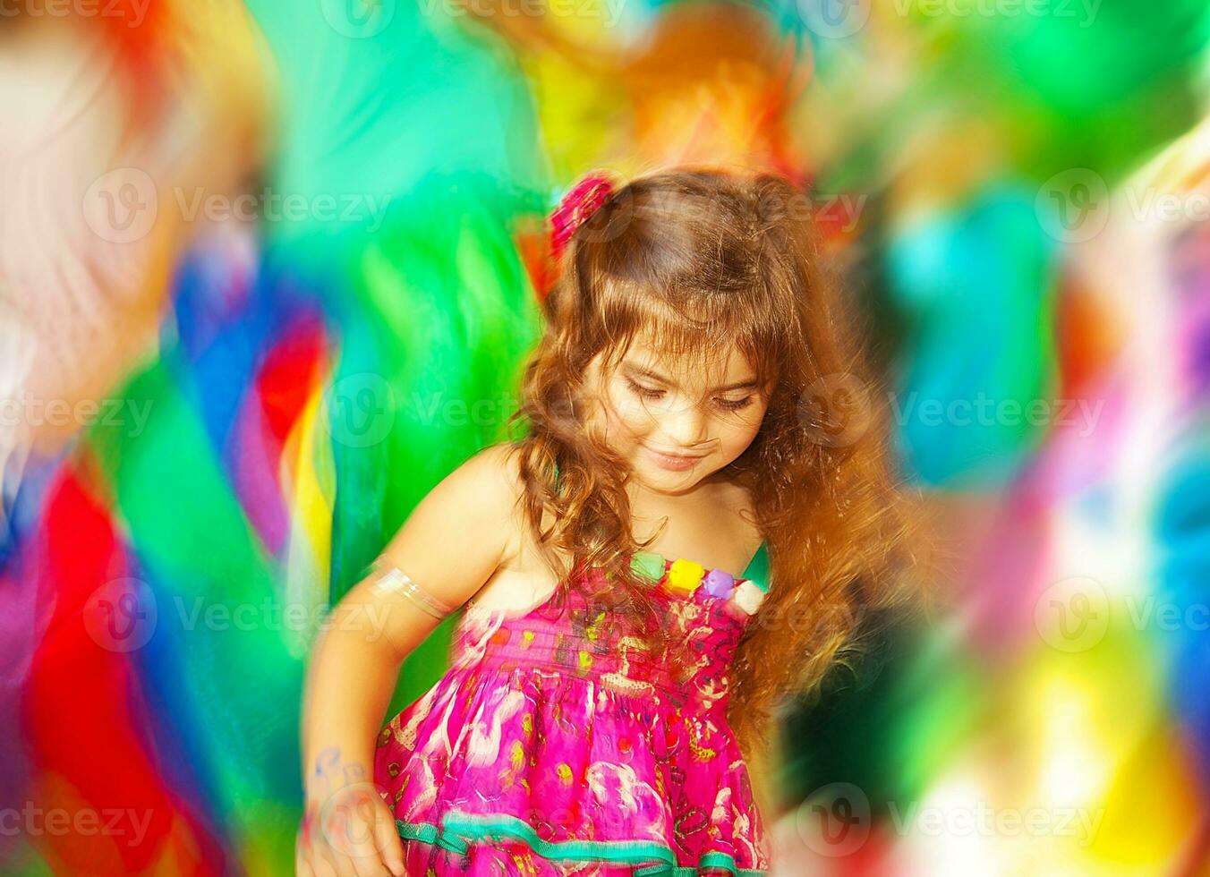 Adorable small girl dancing over blur colors background photo