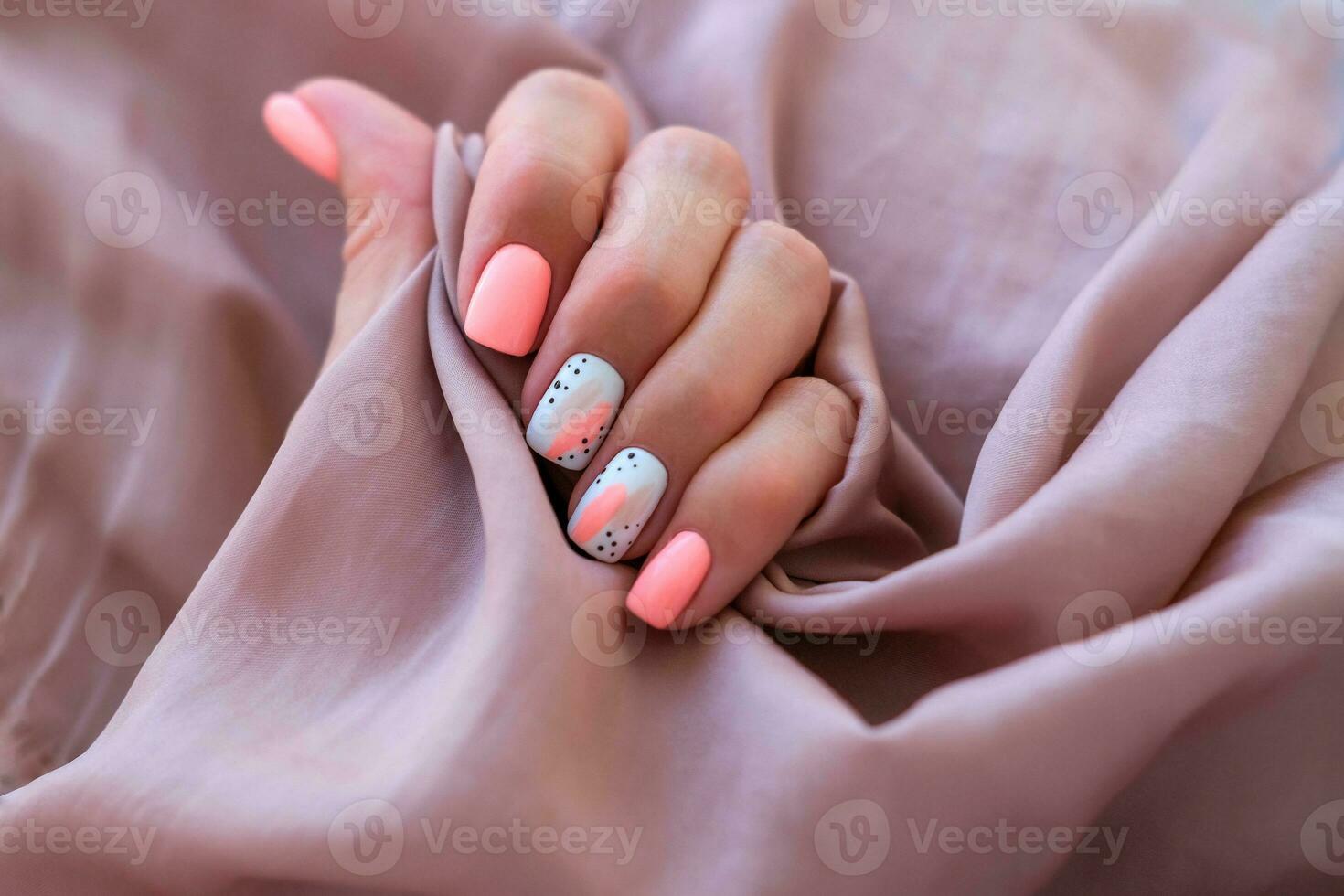 mujer - un mano con un hermosa manicura sostiene un seda tela. primavera tendencia, rosado clavos, dibujo en uñas con gel polaco, goma laca. Copiar espacio. foto