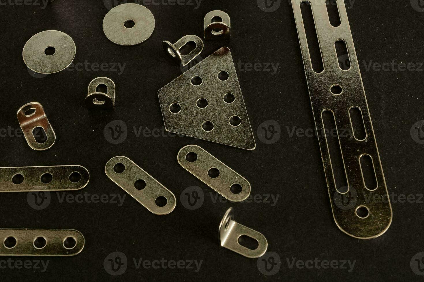 a variety of metal parts on a black surface photo