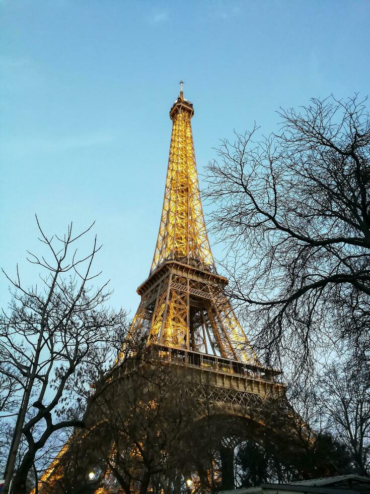 perspectiva de el eiffel torre en París iluminado a el final de el día foto