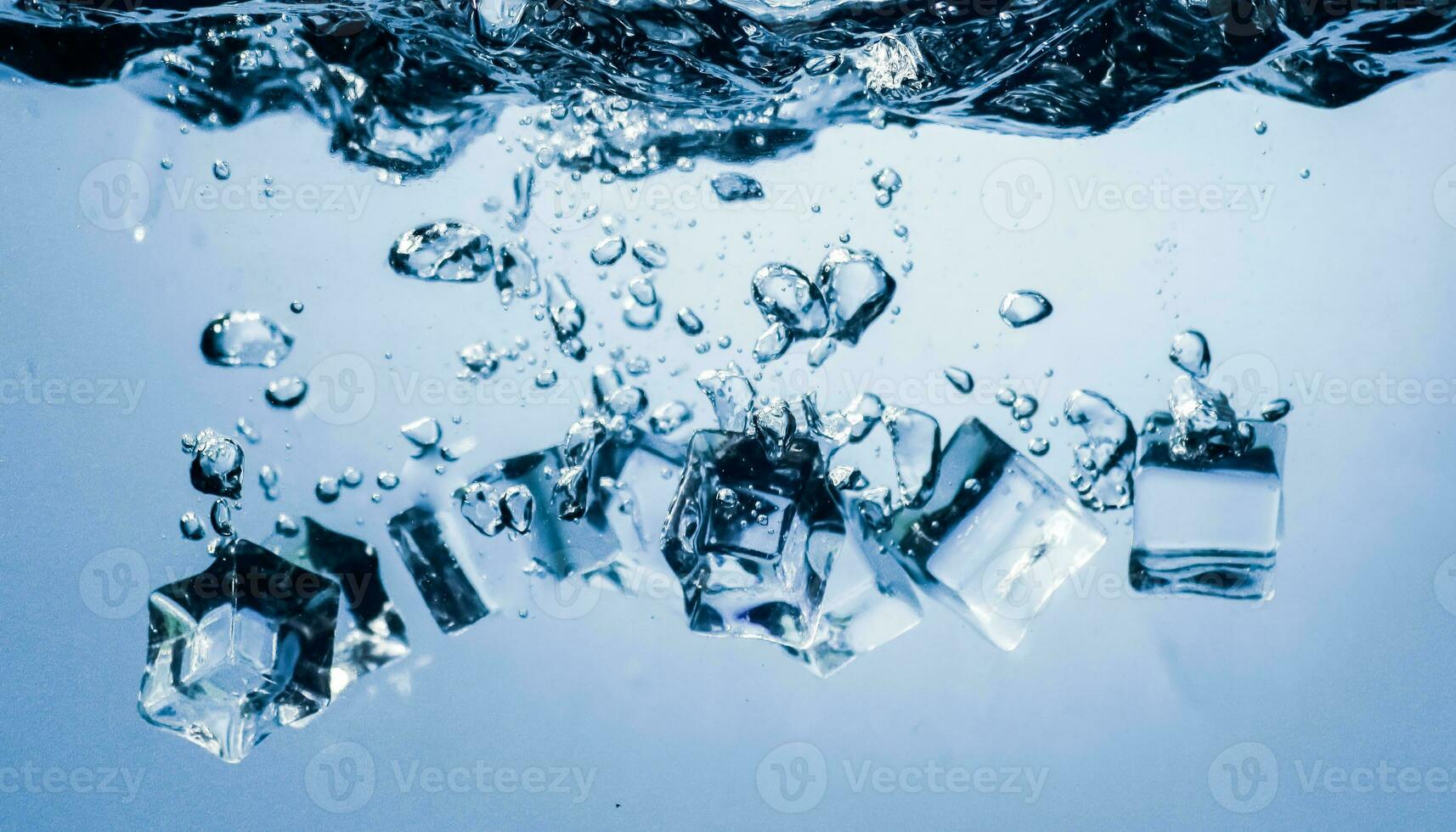 ice cubes falling down. ice cubes on blue background. splash on blue. ice cubes in water photo