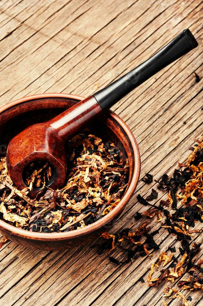 Pipe and tobacco on rustic table photo