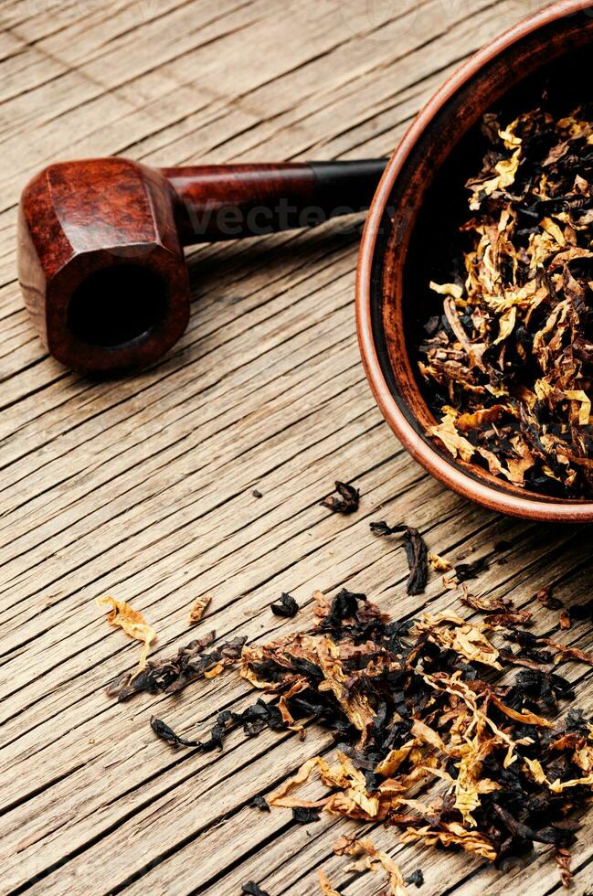 Pipe and tobacco on rustic table photo