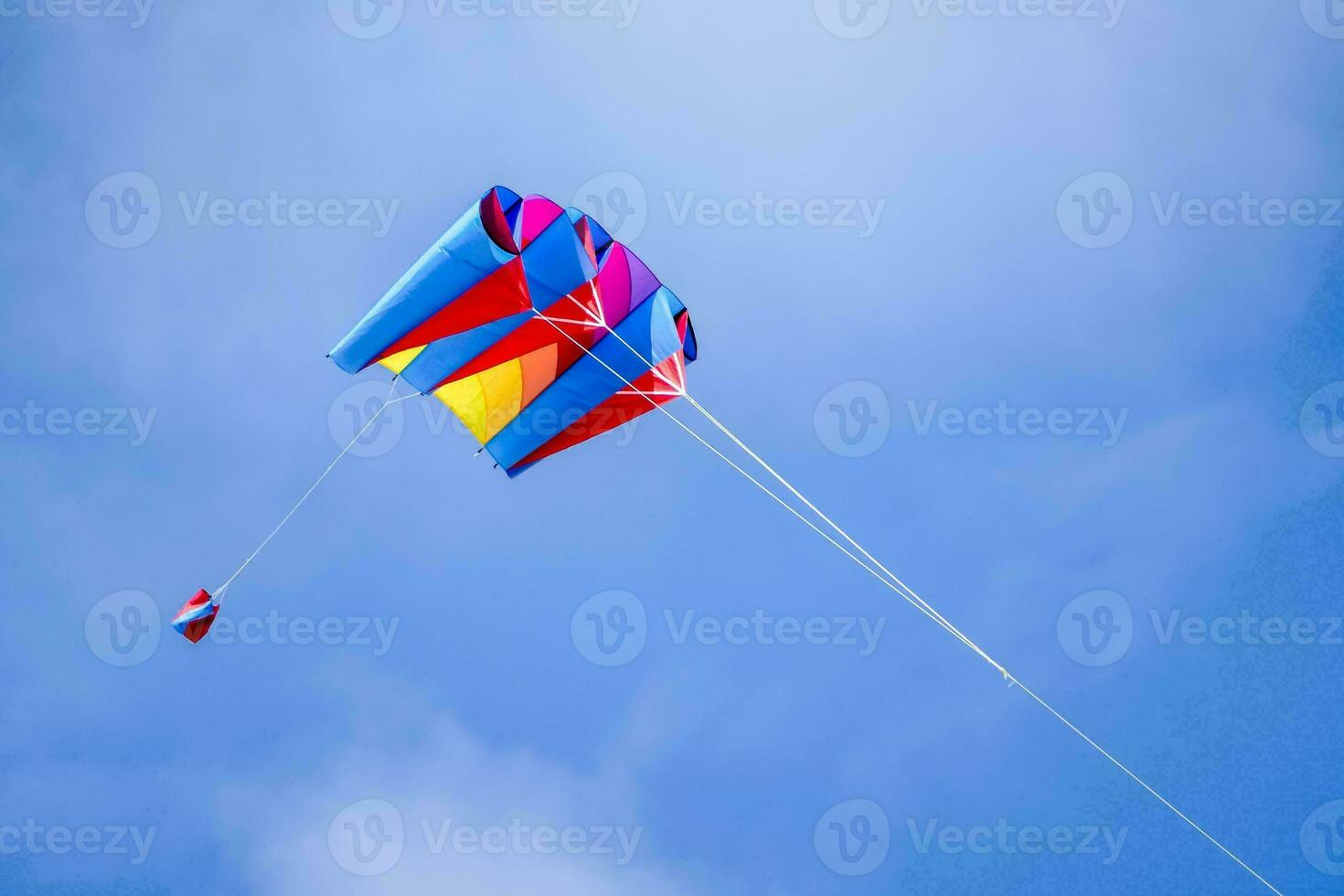 un vistoso cometa volador en el azul cielo foto