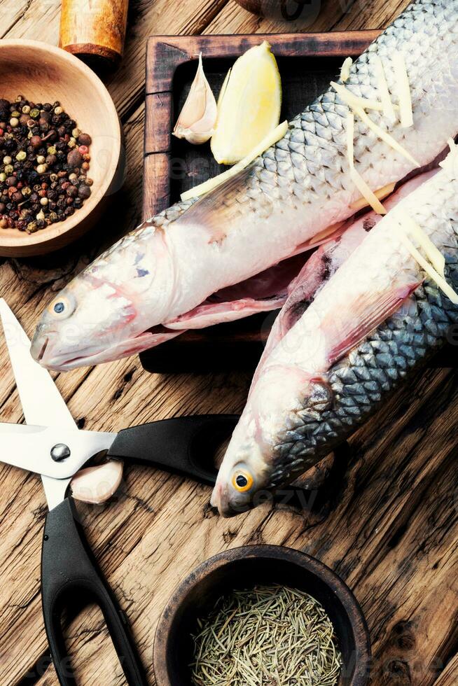 Raw fish with spices on cutting board photo