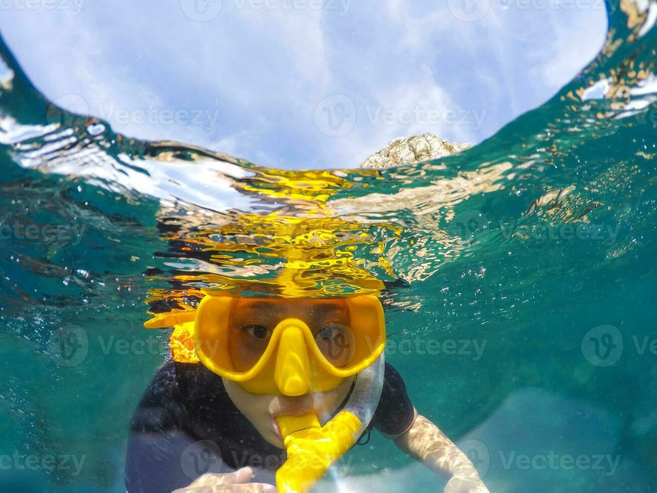 woman face wearing snorkeling mask diving under clear sea water photo