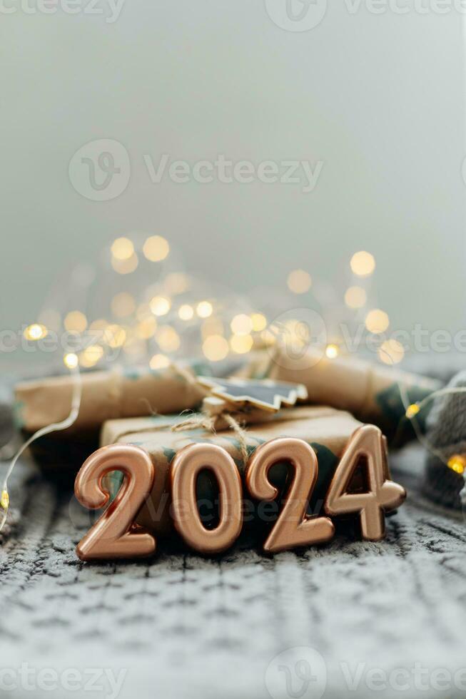 Christmas and New Year Greeting Card. Number 2024 on knitted background. Holiday lights bokeh background. Happy New Year 2024 Concept. photo