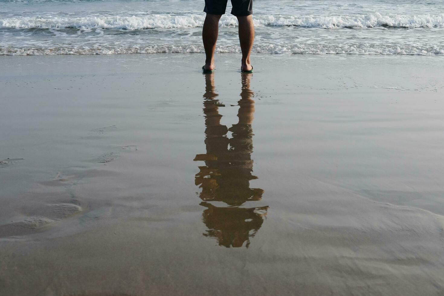 Asian man's feet and leg on the sandy beach with natural sunlight in Summer sea photo