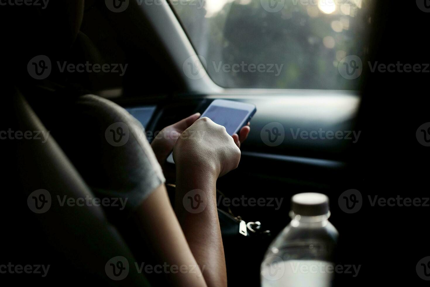 Closed up businesswoman is hand holding smartphone and touch screen for navigator in a car near driver photo
