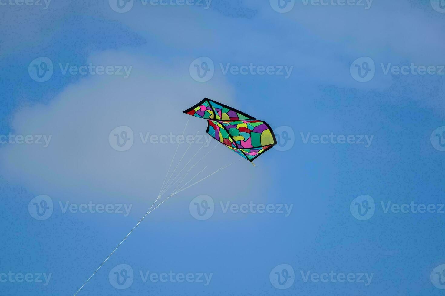 a colorful kite flying in the blue sky photo