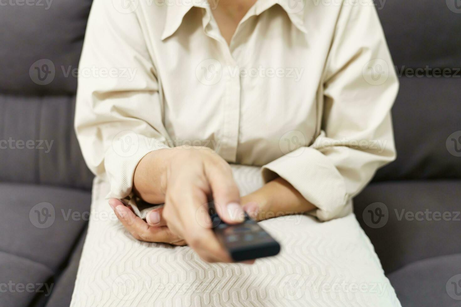 Elderly woman Watching smart TV and using remote controller Hand holding television audio remote control Middle age Asian woman movie Television series spending time at home photo