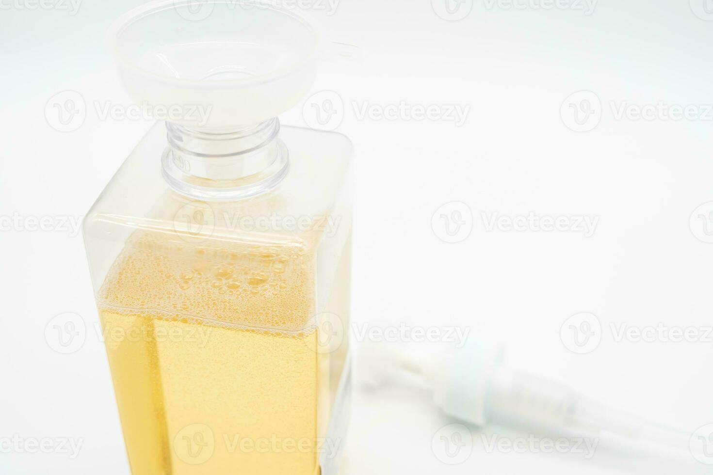 Pour yellow liquid through a funnel. Fill a dispenser with liquid soap or shampoo by pouring it from a refill to reduce plastic waste. Sustainable Zero Waste photo