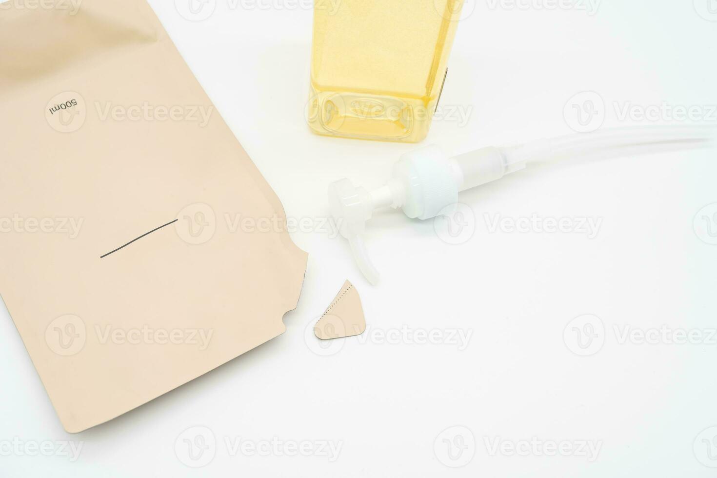 Pour yellow liquid through a funnel. Fill a dispenser with liquid soap or shampoo by pouring it from a refill to reduce plastic waste. Sustainable Zero Waste photo