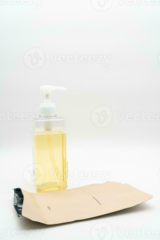 Pour yellow liquid through a funnel. Fill a dispenser with liquid soap or shampoo by pouring it from a refill to reduce plastic waste. Sustainable Zero Waste photo