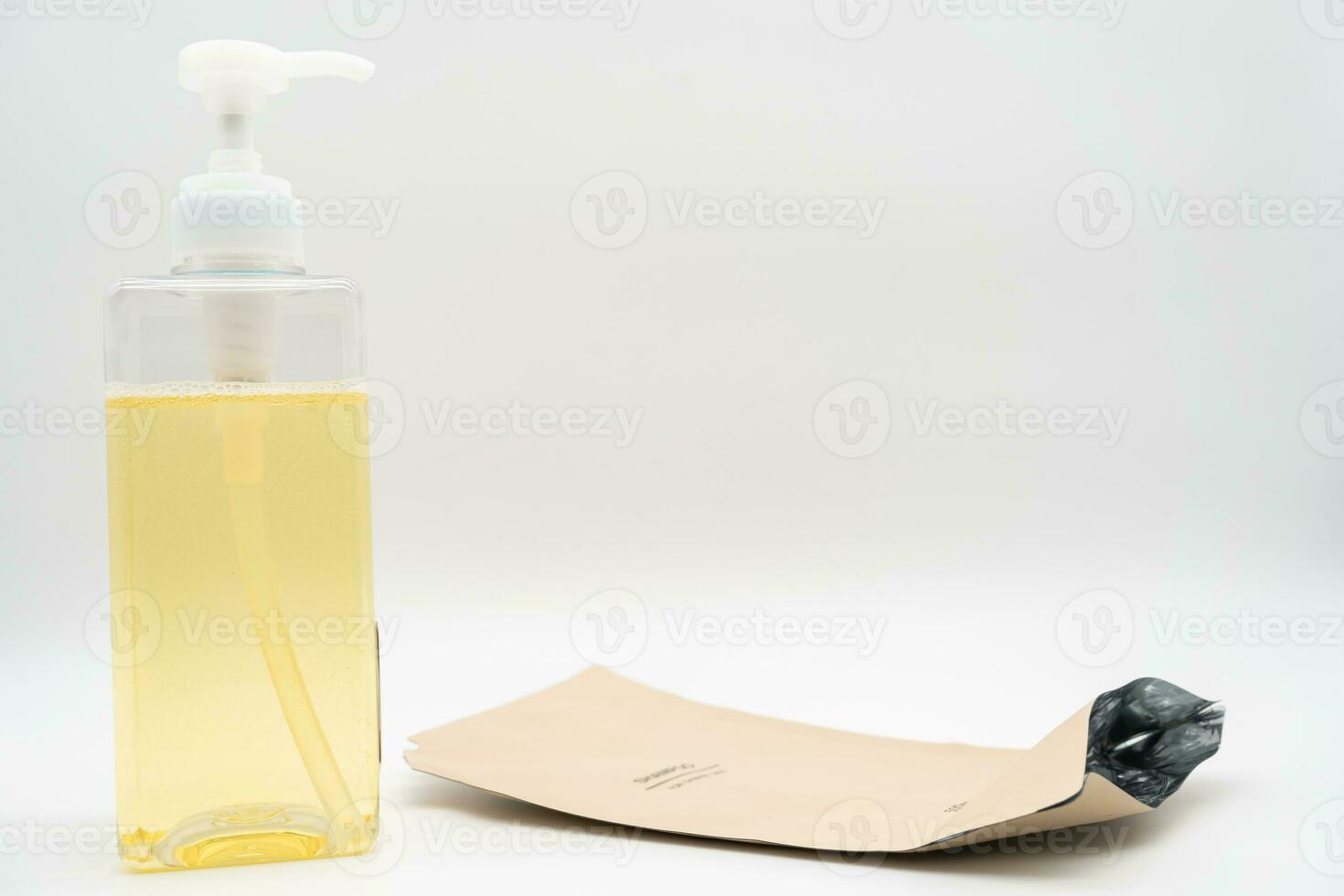 Pour yellow liquid through a funnel. Fill a dispenser with liquid soap or shampoo by pouring it from a refill to reduce plastic waste. Sustainable Zero Waste photo
