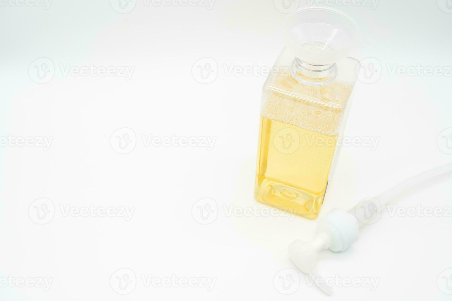 Pour yellow liquid through a funnel. Fill a dispenser with liquid soap or shampoo by pouring it from a refill to reduce plastic waste. Sustainable Zero Waste photo