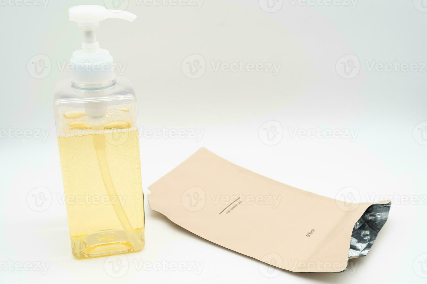 Pour yellow liquid through a funnel. Fill a dispenser with liquid soap or shampoo by pouring it from a refill to reduce plastic waste. Sustainable Zero Waste photo
