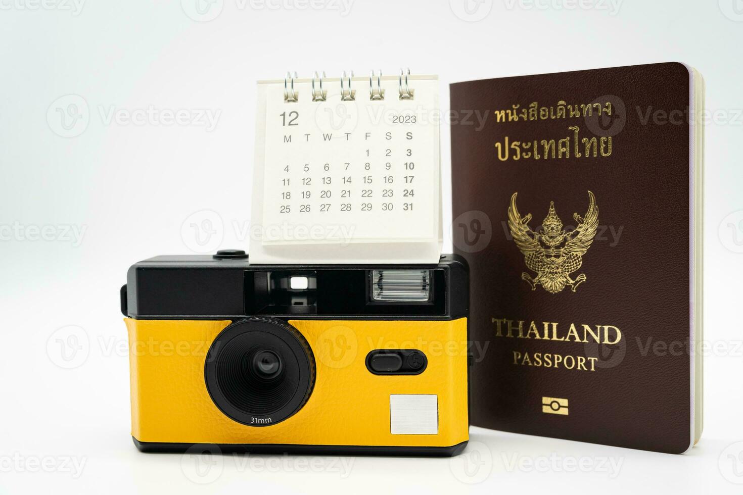 Simple desk calendar for December 2023 and film camera. Calendar and holiday concept with copy space. photo