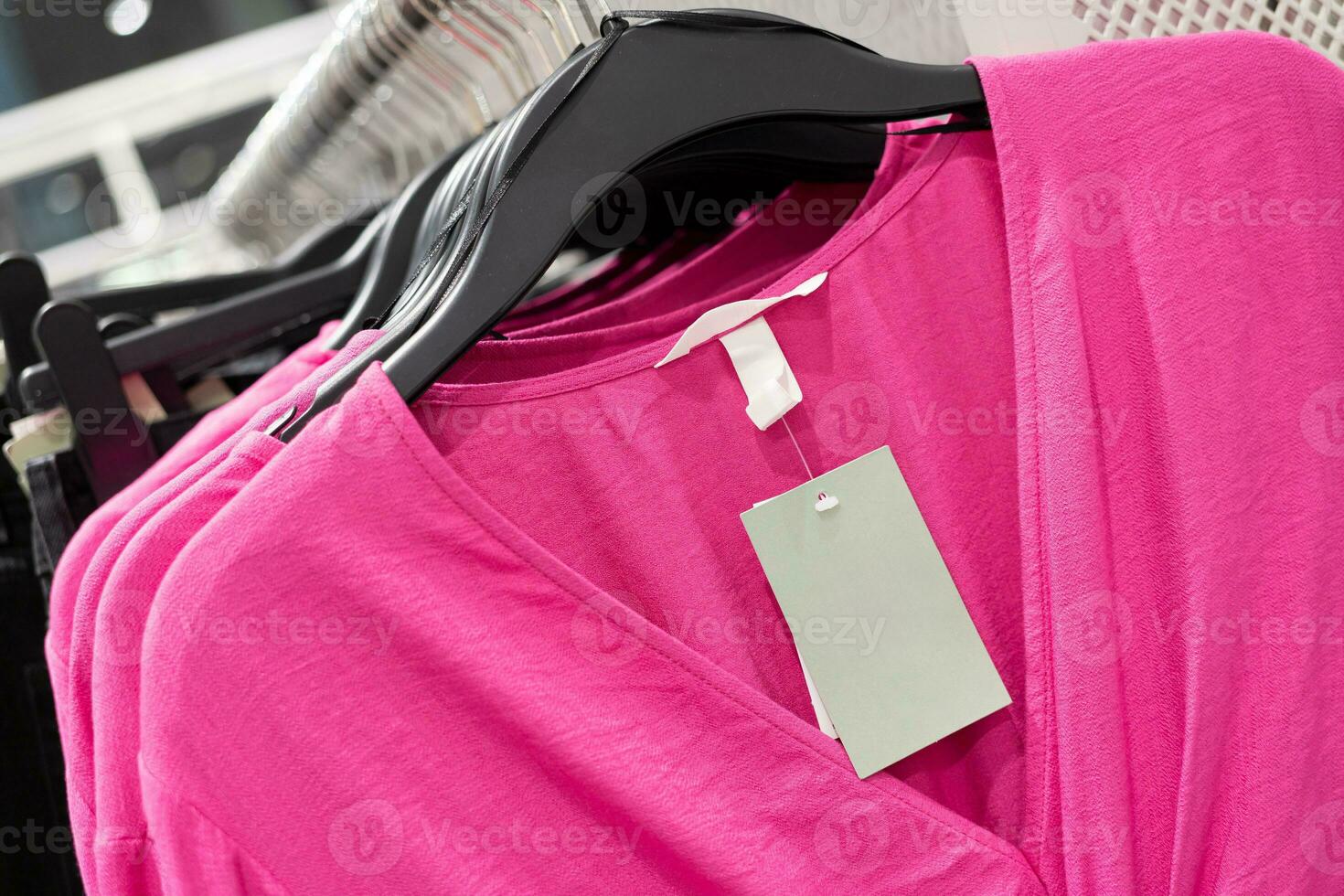 blanco etiqueta con ropa colgar en un estante en un diseñador ropa almacenar. ropa colgando en un ropa estante en un Tienda foto