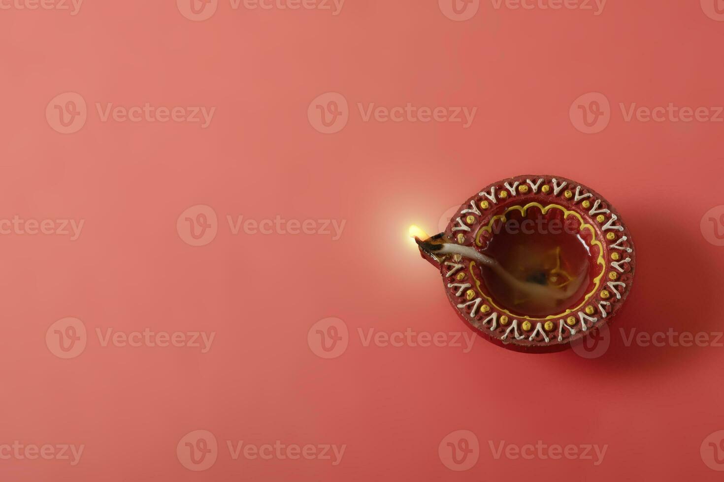 Happy Diwali and Kartika Deepam Festival Greetings - Colorful clay diya lamps on red background photo