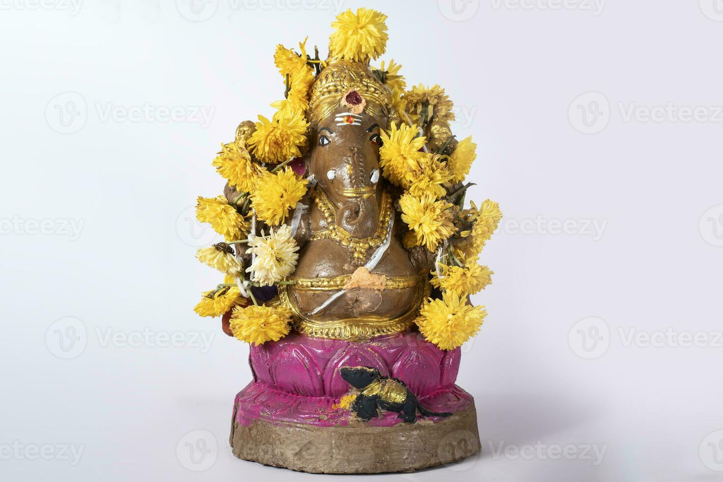 Beautifully painted clay Ganesh statue with garland on white background. photo