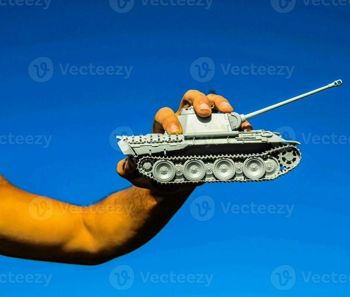 a man holding a small model of a tank photo