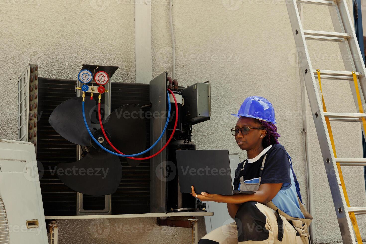 Mechanic looking online for new motor after finding broken internal part during air conditioner checkup. African american repairman checking components stock before replacing broken one photo