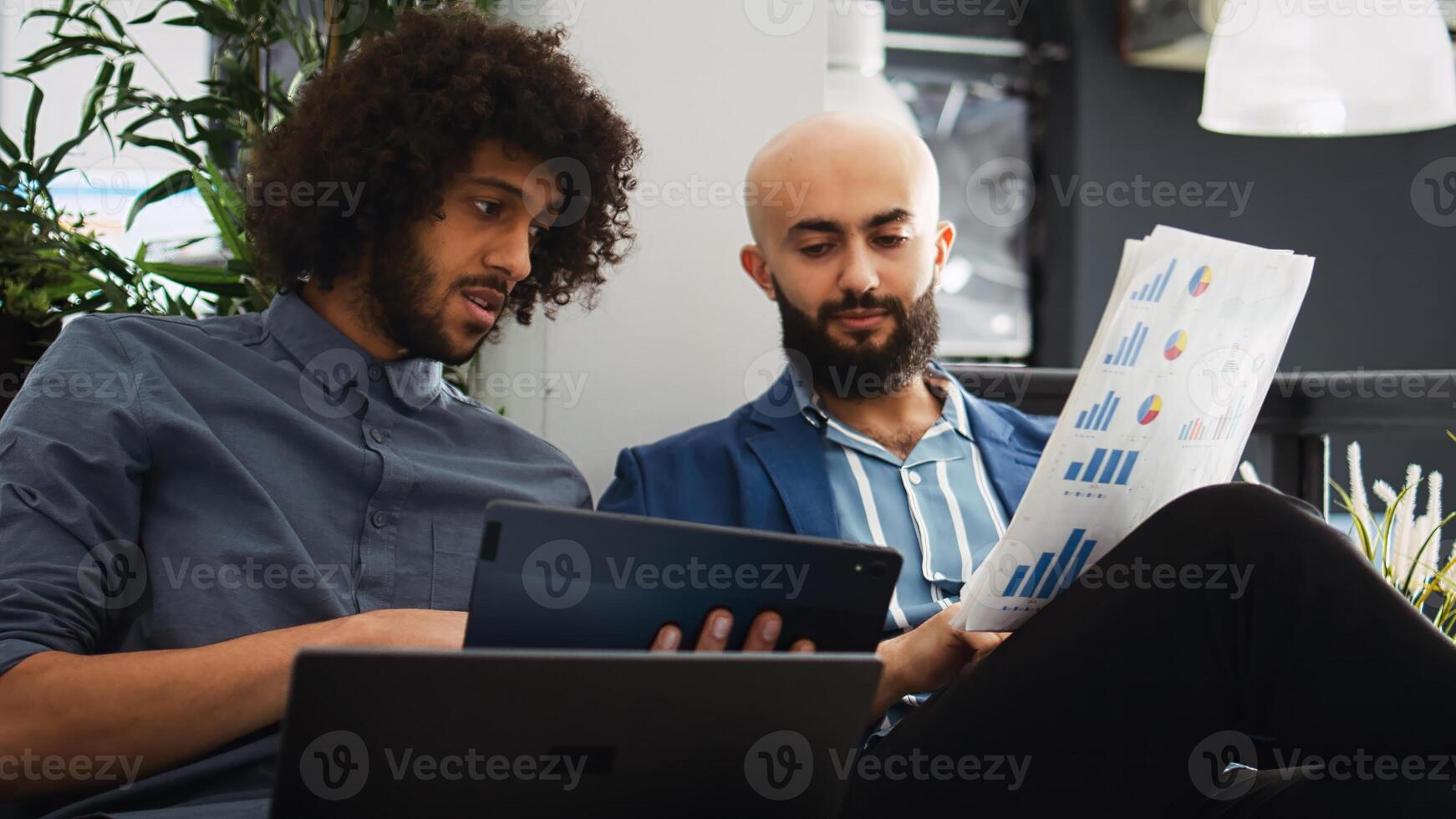 Startup team verify sales report with archived documents and information on laptop, comparing data to create briefing presentation. Coworkers discussing small business development strategy. photo