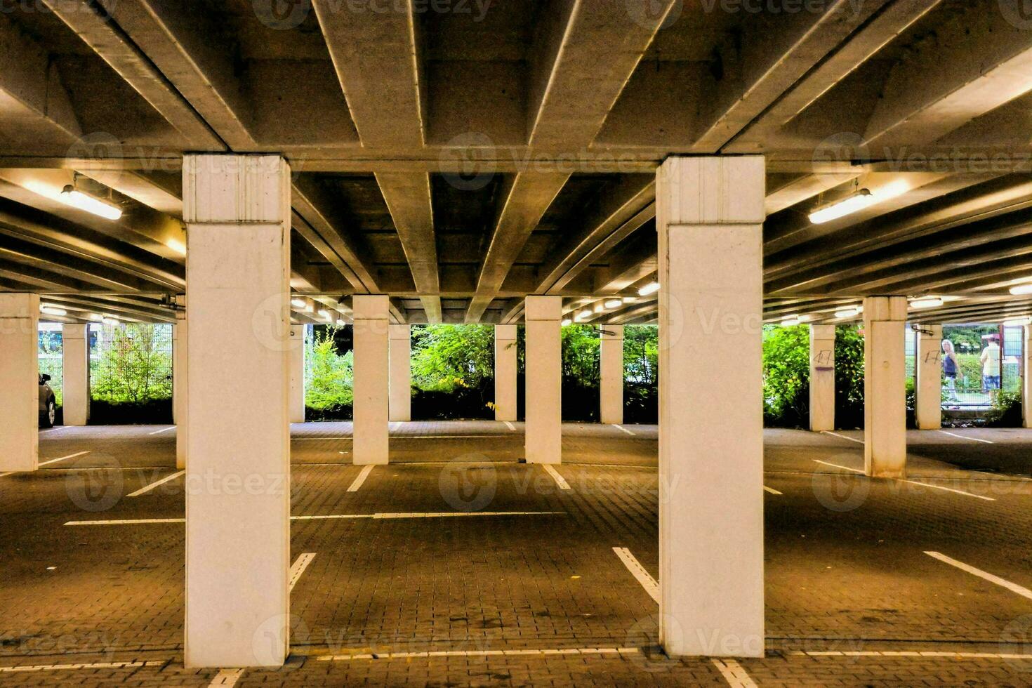 an empty parking lot with columns and trees photo