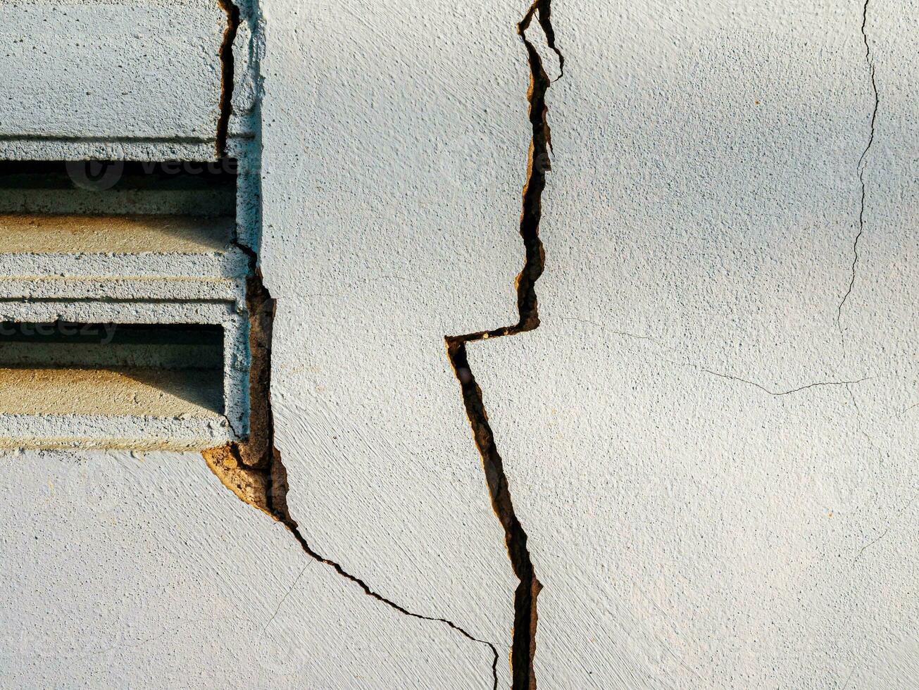 Cracks in the cement wall White cement of buildings damaged by earthquakes photo