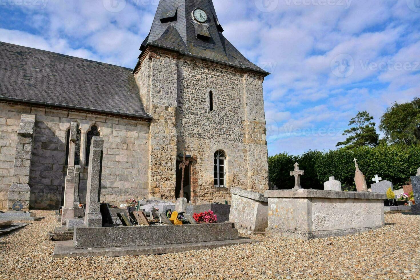 un Iglesia con un campanario y un cementerio foto