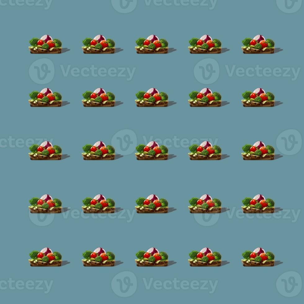 Pattern of vegetables on round wooden board isolated on gray background. photo