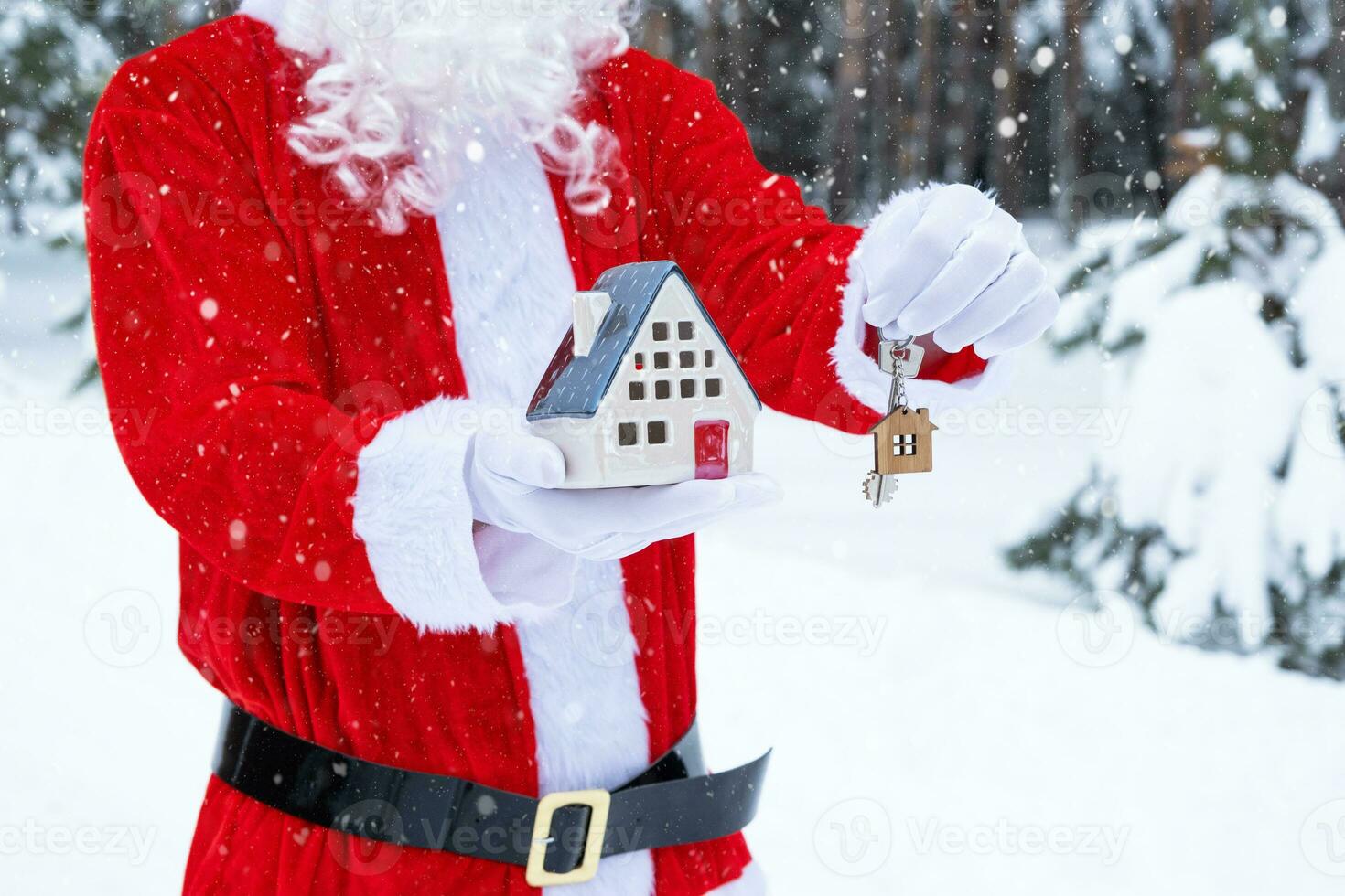 House key with keychain cottage in hands of Santa Claus outdoor in snow. Deal for real estate, purchase, construction, relocation, mortgage. Cozy home. Merry Christmas, new year booking event and hall photo