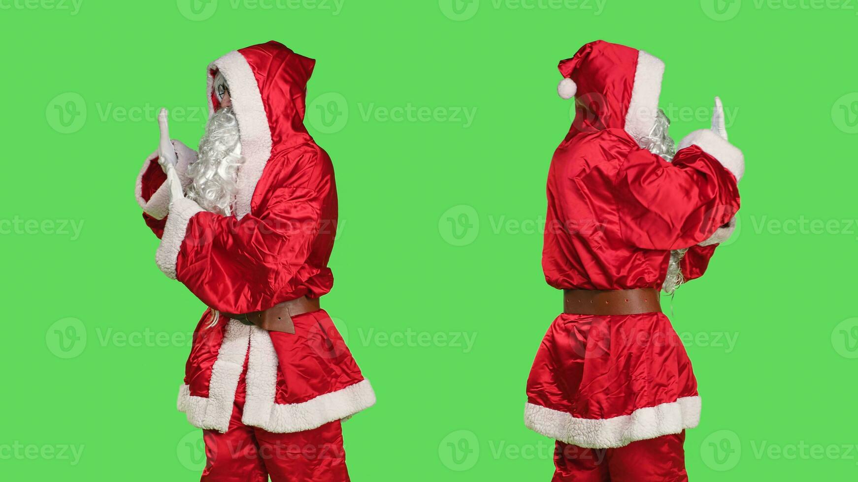 Father christmas pushing something aside, pretending to reject a big object in studio with greenscreen backdrop. Young man portraying santa claus doing dismiss symbol left or right. photo