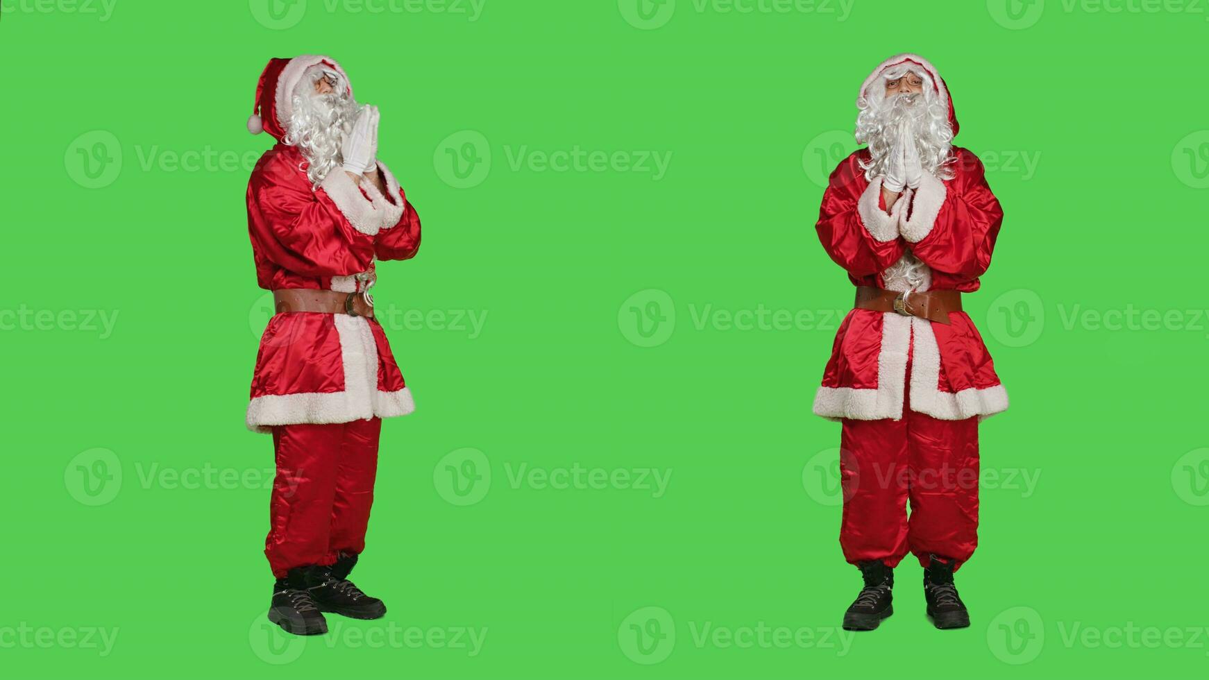Saint nick holds hands in a prayer standing on full body greenscreen backdrop, acting spiritual in studio. Santa claus embodiment talking to jesus, spreading positive christmas eve spirit. photo