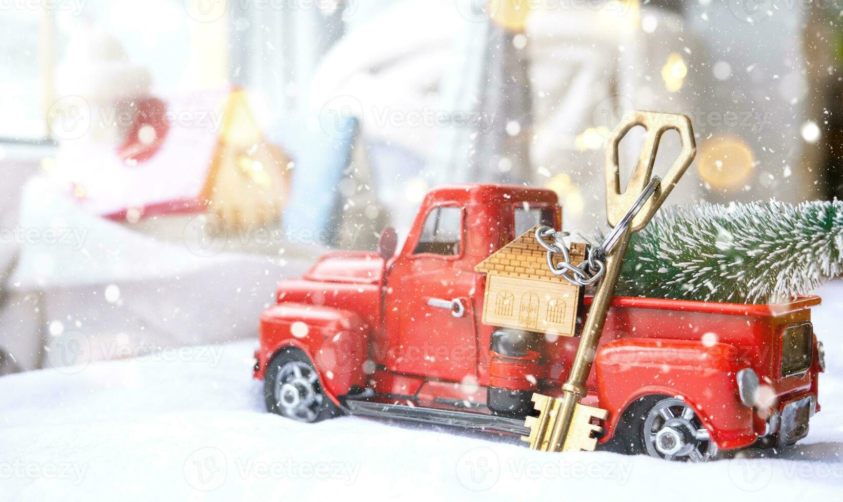 coche retro rojo con un árbol de navidad decora con la llave de la casa en la camioneta para navidad. compra de una casa, mudanza, hipoteca, préstamo, bienes raíces, estado de ánimo festivo, año nuevo foto