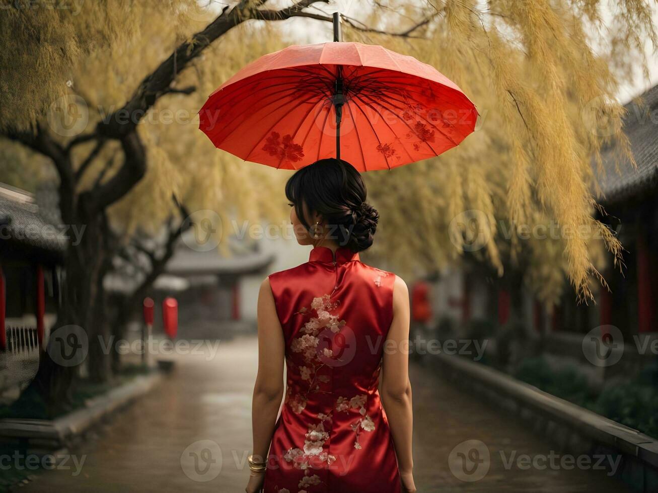 Asian woman in red dress Cheongsam holding red umbrella near willow tree. photo