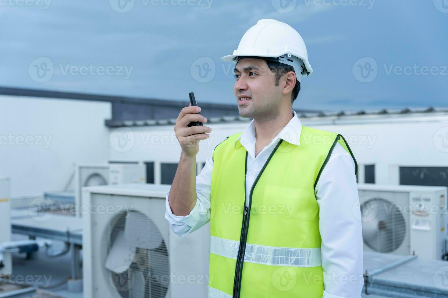 Asian maintenance engineer work on the roof of factory. contractor inspect compressor system and plans installation of air condition systems in construction. technology, walky talky, maintenance photo