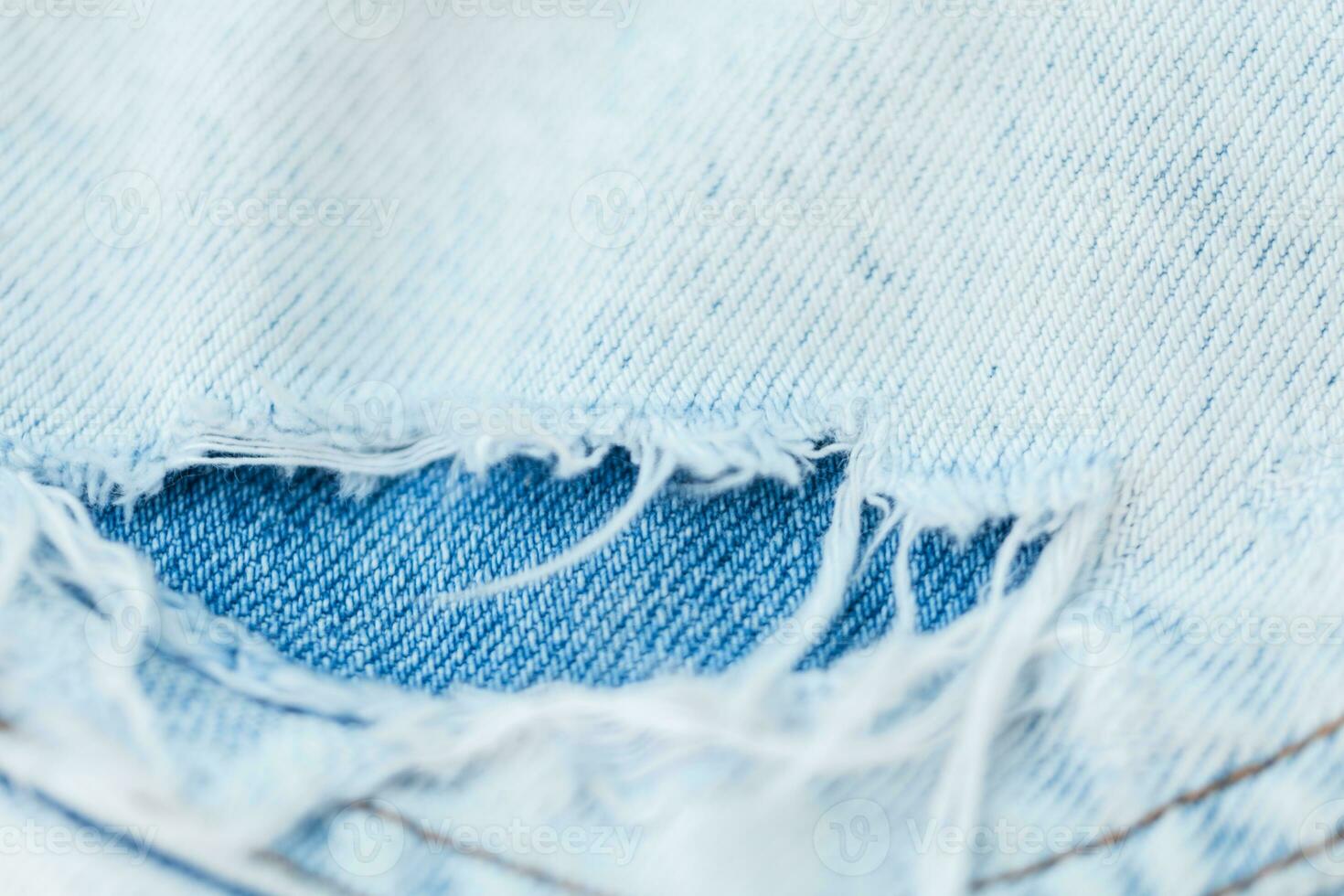 Blue denim fabric texture. close-up. Fashion ripped jeans photo