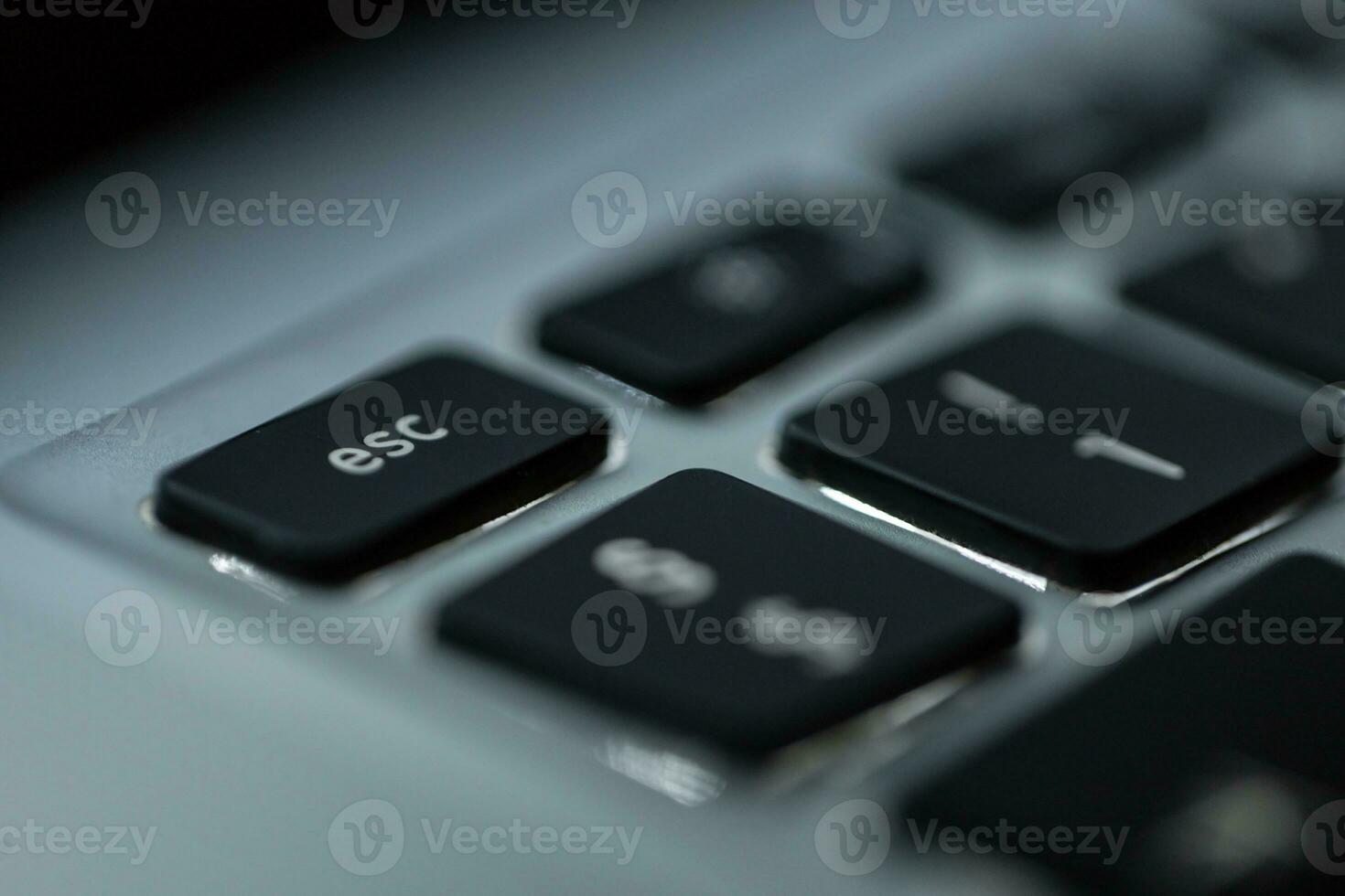 Modern computer keyboard with backlit and focus on the esc button, macro photo