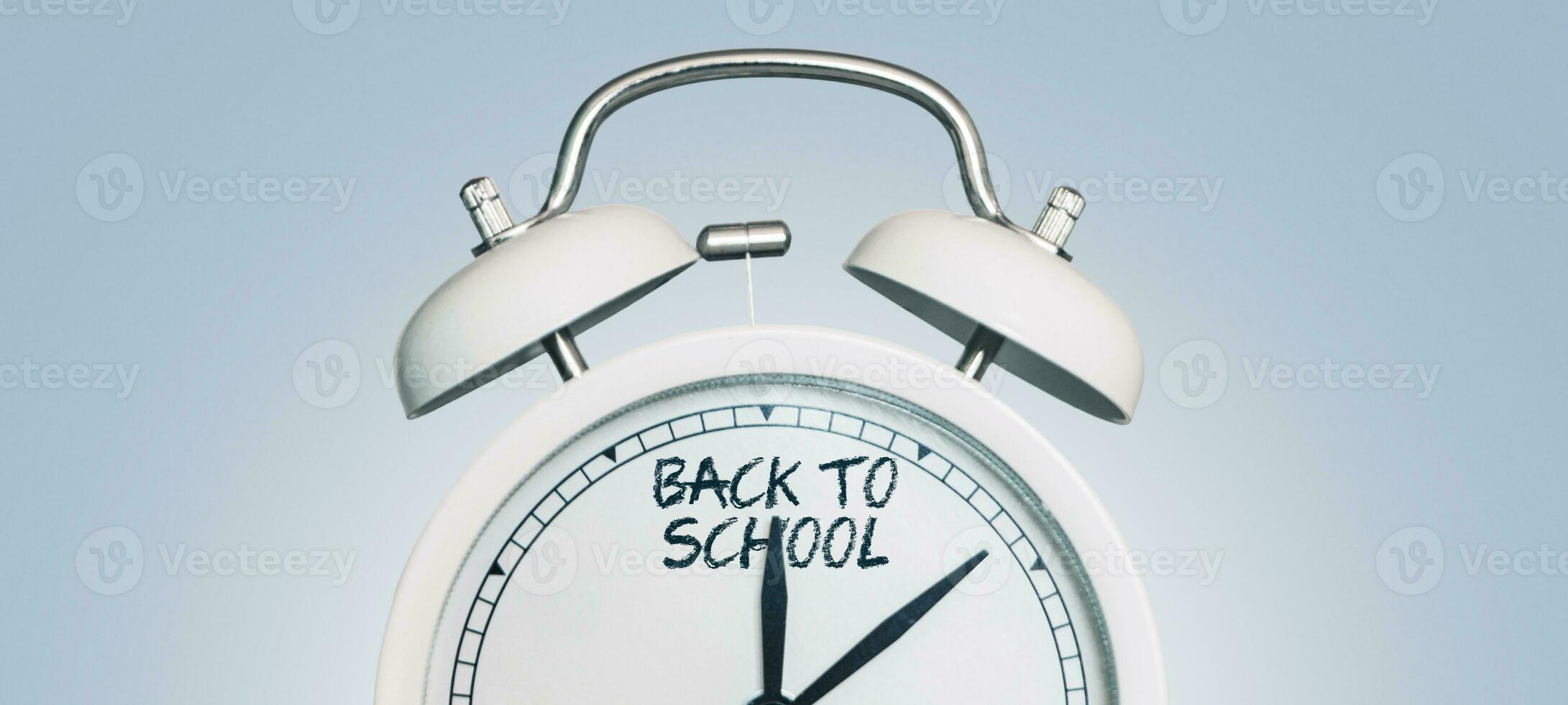 Vintage alarm clock showing back to school arrows. Beginning of the school season. Education. Students start. School and clock, concept photo