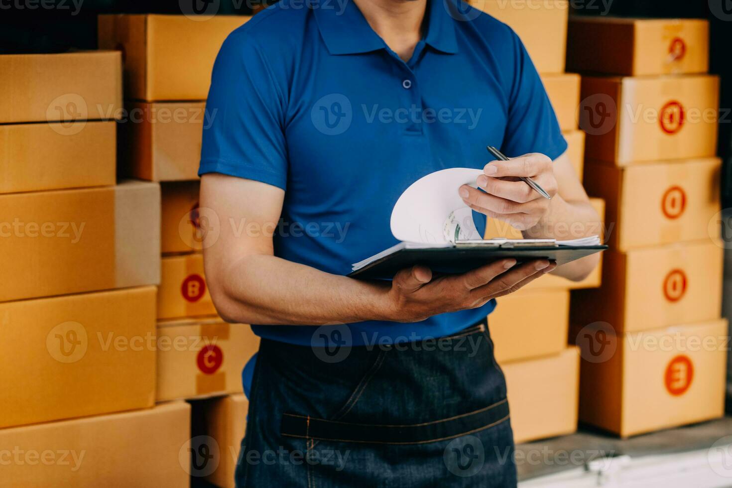 Asian delivery man in cargo van checking boxes. photo