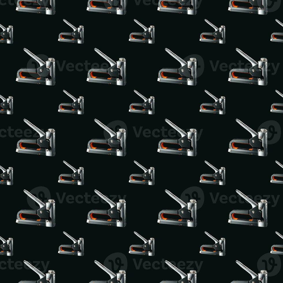 Seamless pattern of construction staplers on a black background. Background for the design. photo