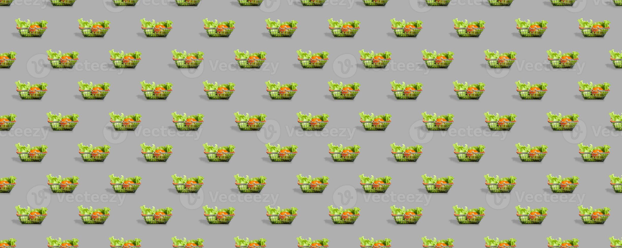 Fresh vegetables in a metal shopping cart. Seamless pattern of shopping baskets isolated on gray background. photo