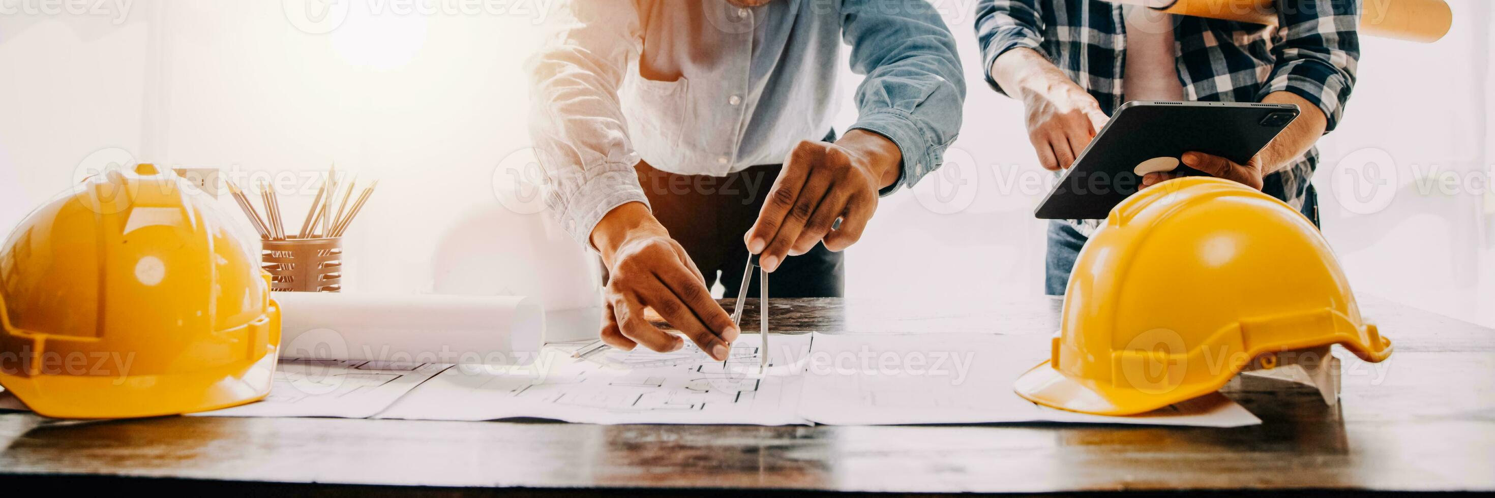 Construction and structure concept of engineer working drawing on blueprint meeting for project working with partner on model building and engineering tools in working site, construction concept. photo