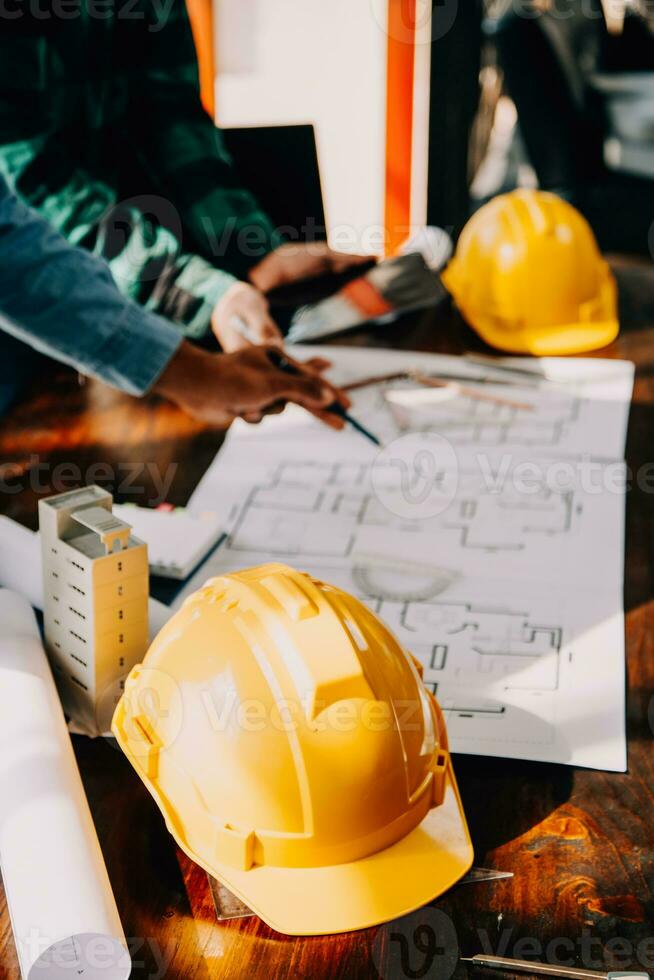 Construction and structure concept of engineer working drawing on blueprint meeting for project working with partner on model building and engineering tools in working site, construction concept. photo